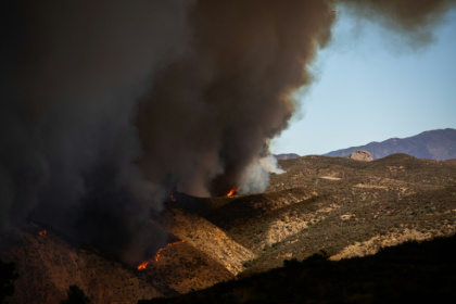 Flames race up the hill as the plume of smoke from the Hughes Fire fills the sky in Castaic, California Flames race up the hill as the plume of smoke from the Hughes Fire fills the sky in Castaic, California