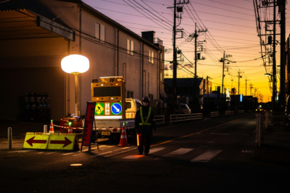 A worker controls the traffic as rescue operations continue for a truck driver after his vehicle plunged into a sinkhole in Yashio A worker controls the traffic as rescue operations continue for a truck driver after his vehicle plunged into a sinkhole in Yashio