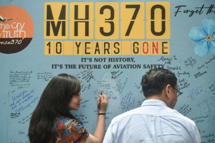 A woman writes a message during an event to mark the 10th year since the Malaysia Airlines flight MH370 disappeared on March 8, 2014 A woman writes a message during an event to mark the 10th year since the Malaysia Airlines flight MH370 disappeared on March 8, 2014
