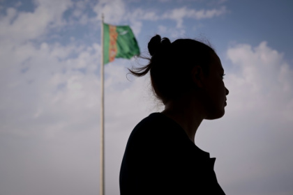 A woman pictured before the Turkmenistan flag in the capital, Ashgabat A woman pictured before the Turkmenistan flag in the capital, Ashgabat