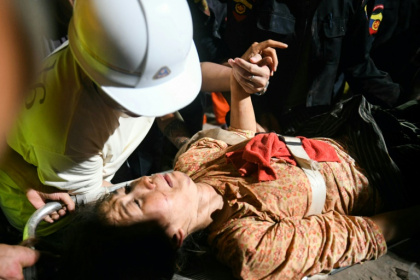 Rescuers pulled a woman alive from the wreckage of a collapsed apartment building in Mandalay Rescuers pulled a woman alive from the wreckage of a collapsed apartment building in Mandalay