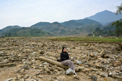 Nguyen Thi Kim sitting on a pillar of a destroyed house at the original site of Lang Nu village in Lao Cai province, after part of it was wiped away in a landslide triggered by Typhoon Yagi Nguyen Thi Kim sitting on a pillar of a destroyed house at the original site of Lang Nu village in Lao Cai province, after part of it was wiped away in a landslide triggered by Typhoon Yagi