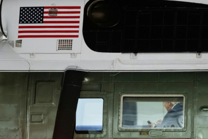 US President Donald Trump looks at his cellphone aboard Marine One - SAUL LOEB (AFP)