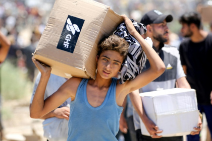 A boy carries a box of relief supplies from the Gaza Humanitarian Foundation in the central Gaza Strip - Eyad BABA (AFP) A boy carries a box of relief supplies from the Gaza Humanitarian Foundation in the central Gaza Strip - Eyad BABA (AFP)