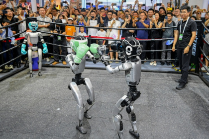 People watch humanoid robots boxing at an exhibition during the World AI Conference in Shanghai - - (AFP)
