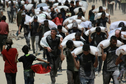Palestinians carrying sacks of flour after trucks carrying humanitarian aid entered northern Gaza - BASHAR TALEB (AFP) Palestinians carrying sacks of flour after trucks carrying humanitarian aid entered northern Gaza - BASHAR TALEB (AFP)