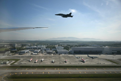 A Malaysian F-18 escort plane is seen from the cabin of Air Force One as it prepares to land at Kuala Lumpur - ANDREW CABALLERO-REYNOLDS (AFP)