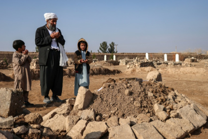 Gul Ahmad (centre) along with his deceased stepbrother Habibullah's son Waheed (right) and Saeed offering prayers over his grave in Ghunjan - Mohsen KARIMI (AFP)