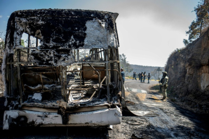 Members of the Mexican National Guard and Army inspected vehicles set on fire in Michoacan state after the killing of the drug kingpin - Enrique CASTRO (AFP)