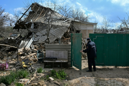 A Russian police officer inspects a destroyed house following an air attack in Yasynuvata, in the Russia-controlled part of Ukraine's Donetsk region - STRINGER (AFP)