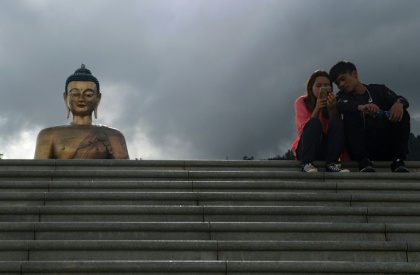 People look at a phone as they sit beside the Buddha Dordenma statue in Bhutan's capital Thimphu on August 25, 2018 - Arun SANKAR (AFP)