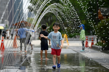 Children cooling off in a fountain in Seoul on August 4. South Korea's heat record has been broken three times over the past week, with the latest all-time high set at 42.5C in the city of Yangsan - GREG BAKER (AFP)
