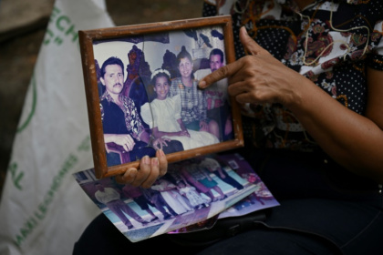 Marlene Nino points to an old photo of her sister Doris, who was killed when her building collapsed in the 7.4 magnitude earthquake in Cali, Colombia - Raul ARBOLEDA (AFP)