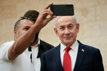 Israeli Prime Minister Benjamin Netanyahu takes a selfie with a supporter as he arrives to cast his ballot during his Likud party's primary elections on August 17, 2026 - Ohad Zwigenberg (AFP)