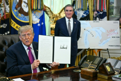 US President Donald Trump (L), alongside Secretary of the Interior Doug Burgum, displays an executive order he signed that aims to rename Lake Ontario to Lake America - Jim WATSON (AFP)