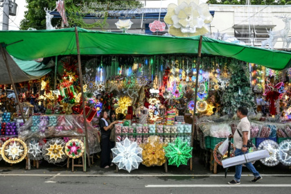 A man walks past Christmas decorations at a market in Quezon City, Metro Manila - Jam STA ROSA, Jam STA ROSA (AFP)