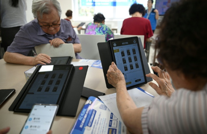 Elderly people using tablets during a government-organised digital survival training course at a senior community centre in Suwon - Jung Yeon-je (AFP)
