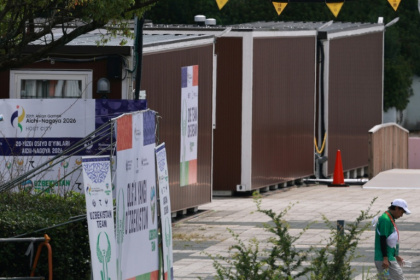 A man walks past temporary container huts being used to house athletes for the 2026 Asian Games at the Garden Pier in Nagoya - DAVID GRAY (AFP)