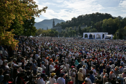 Worshippers packed a field in Lourdes - Ed JONES (AFP)